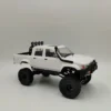 toyota hilux 96 wpl c64 auto rc escala 1-16 sobre superficie rocosa o fondo blanco