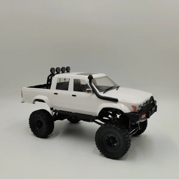 toyota hilux 96 wpl c64 auto rc escala 1-16 sobre superficie rocosa o fondo blanco