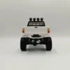 toyota hilux 96 wpl c64 auto rc escala 1-16 sobre superficie rocosa o fondo blanco
