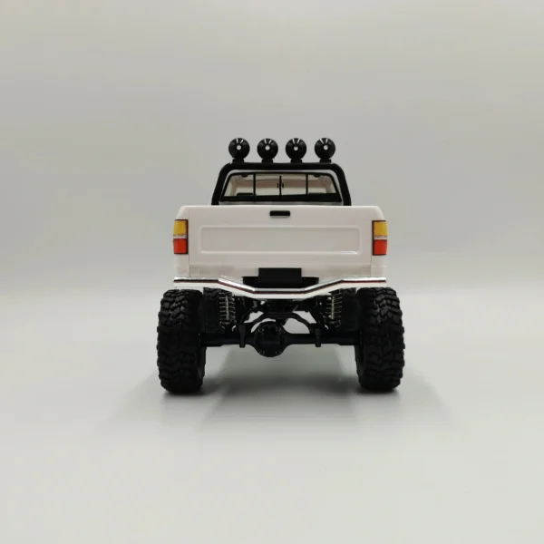 toyota hilux 96 wpl c64 auto rc escala 1-16 sobre superficie rocosa o fondo blanco