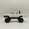 toyota hilux 96 wpl c64 auto rc escala 1-16 sobre superficie rocosa o fondo blanco