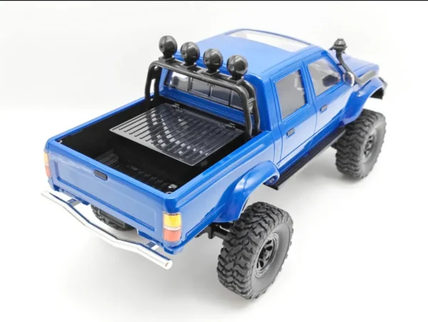 toyota hilux 96 wpl c64 auto rc escala 1-16 sobre superficie rocosa o fondo blanco