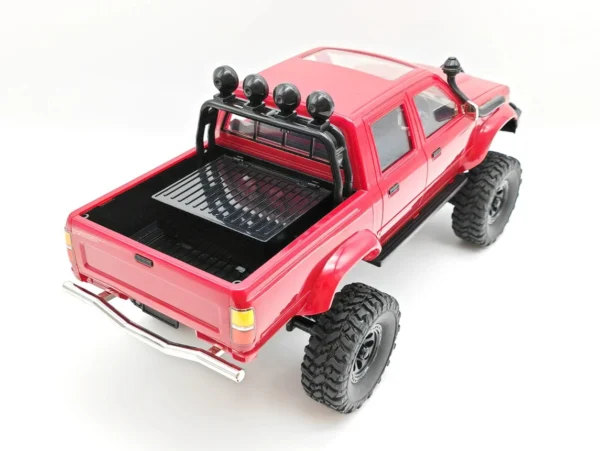 toyota hilux 96 wpl c64 auto rc escala 1-16 sobre superficie rocosa o fondo blanco