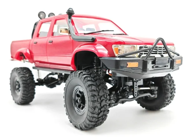 toyota hilux 96 wpl c64 auto rc escala 1-16 sobre superficie rocosa o fondo blanco